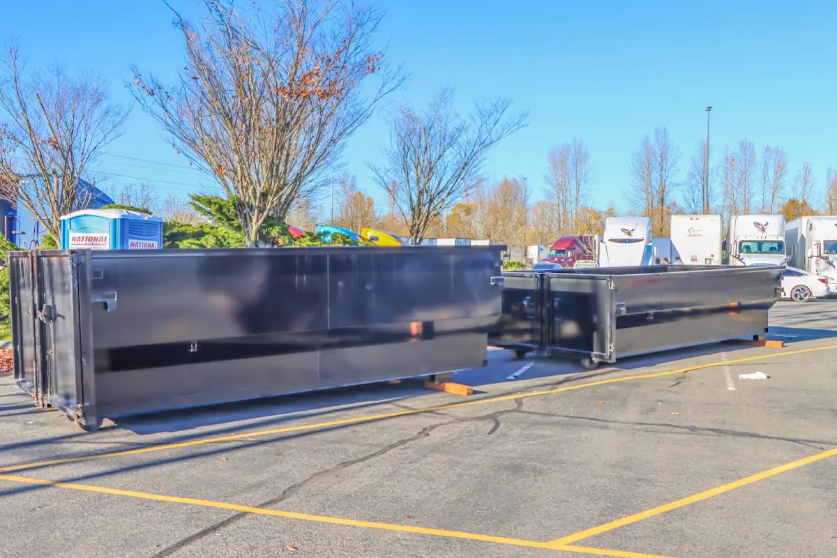 Professional dumpster rental service with roll-off container on residential driveway in Overland